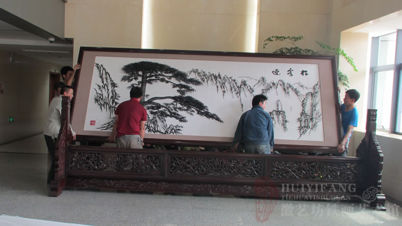 昆明長水國際機場定制的辦公樓大廳大型紅木迎客松鐵畫屏風-正在安裝鐵畫屏風
