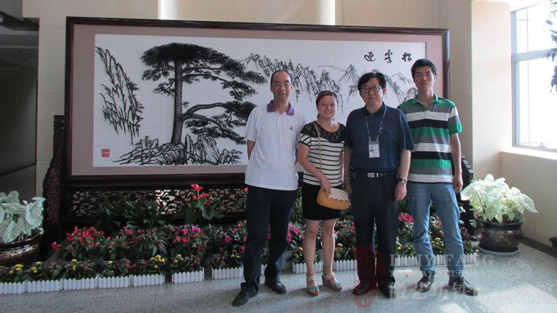 昆明長水國際機(jī)場定制的辦公樓大廳大型紅木迎客松鐵畫屏風(fēng)與客戶合影